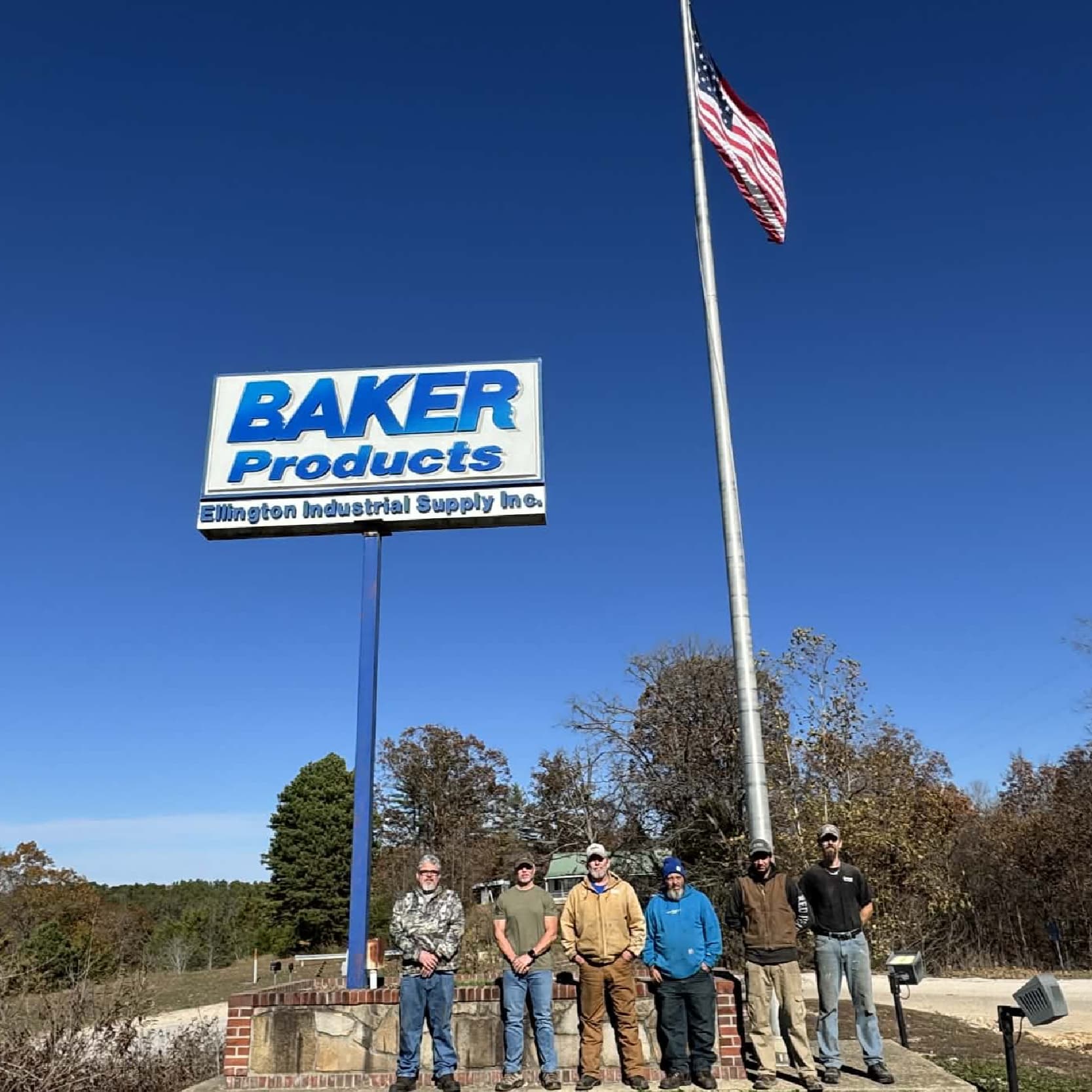Image of employees standing in front of Baker Products Sign