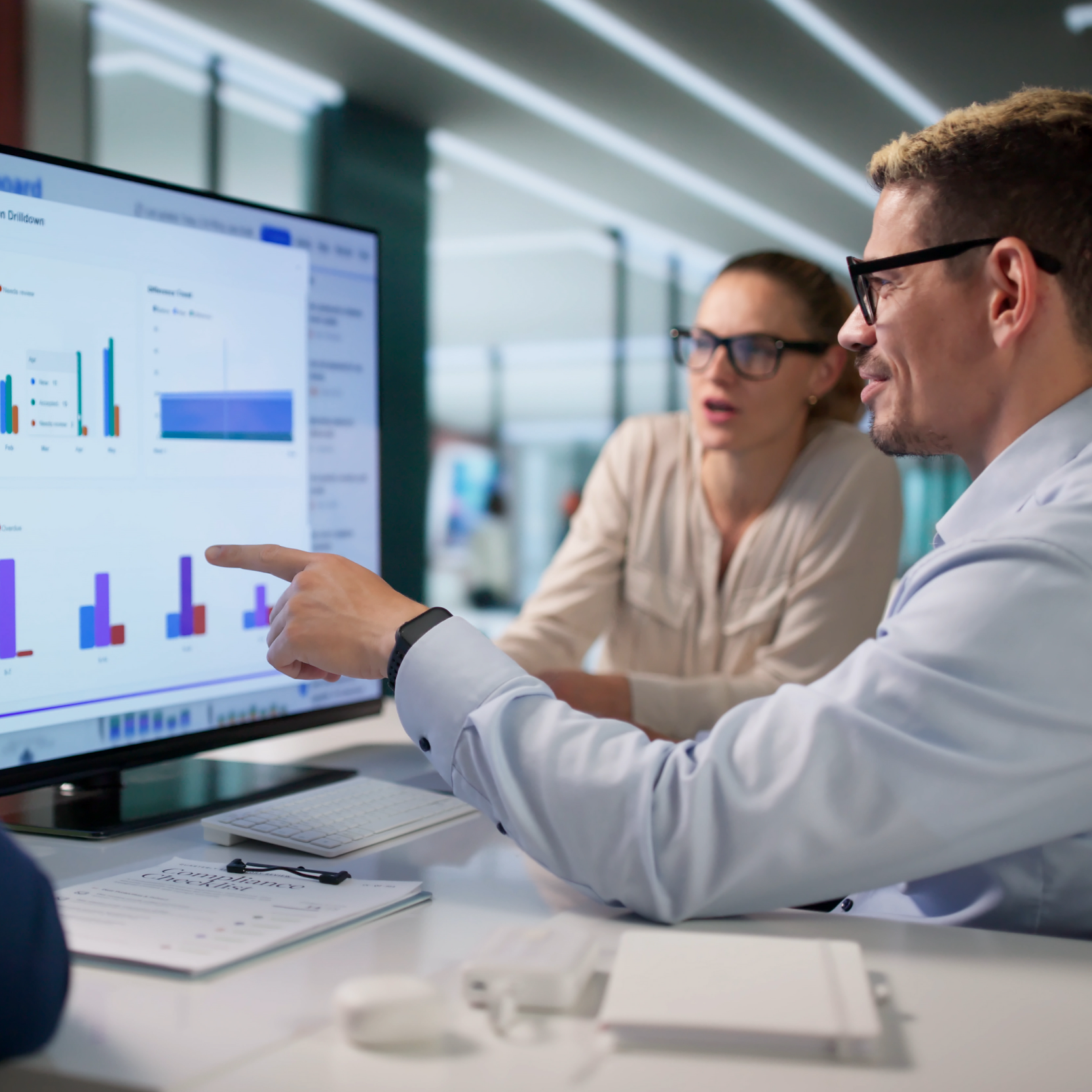 Stock Image of two workers looking at charts on computer